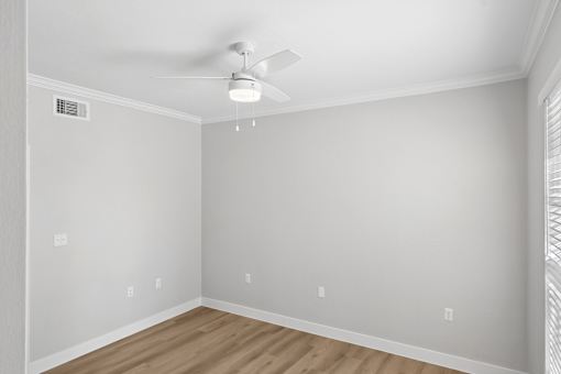 A room with a ceiling fan and light fixture.