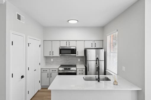 A kitchen with white cabinets and appliances.