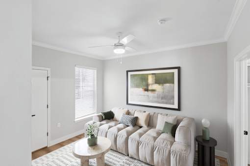A living room with a couch, a table, and a painting on the wall.