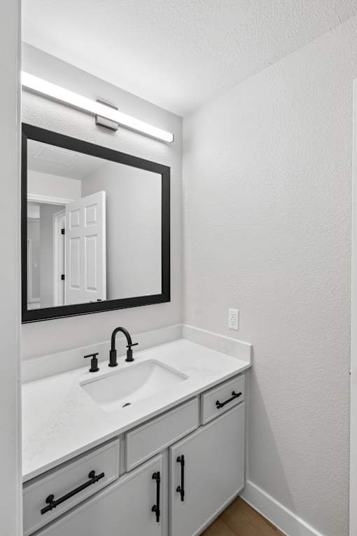 A bathroom with a sink and mirror.
