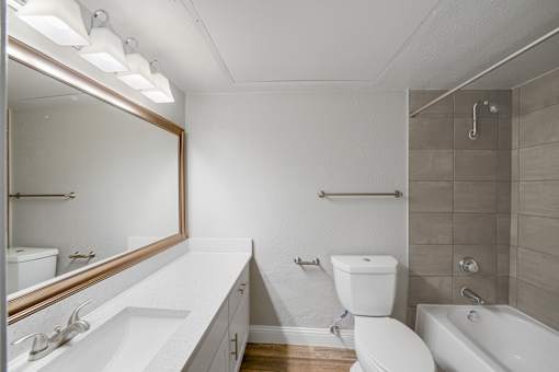 A white bathroom with a toilet, sink, and bathtub.
