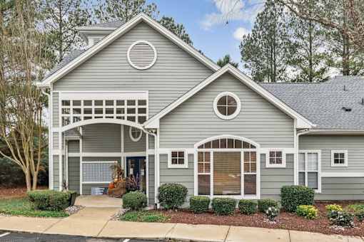 A grey house with a white door and windows.