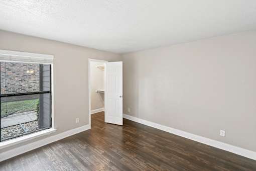 A room with a white door and a window overlooking a cityscape.