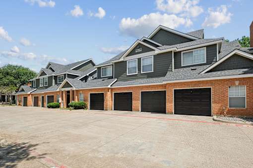 A row of houses with black garage doors.