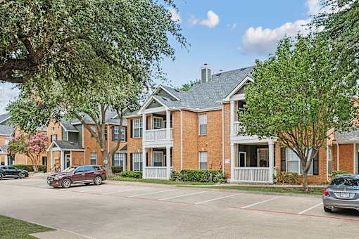 A red brick building with a tree in front of it.