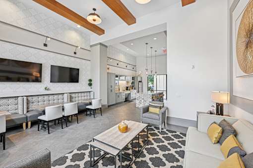 A modern living room with a grey and white patterned rug and a wooden coffee table.
