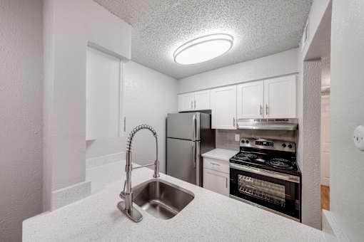 A kitchen with a stainless steel refrigerator, oven, and microwave.