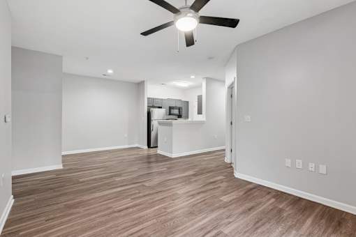 A room with a ceiling fan and wooden flooring.