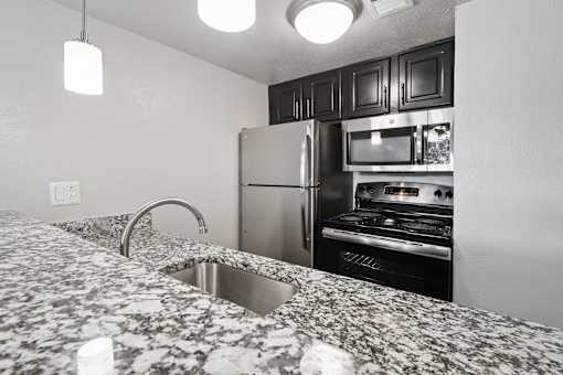A kitchen with granite countertops and stainless steel appliances.
