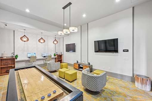 A shiny pool table is in the middle of a room with a yellow chair and a television.