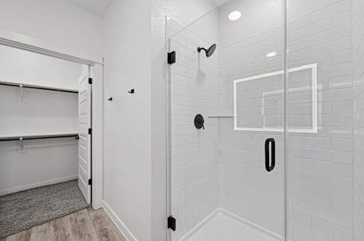 A white bathroom with a walk in shower.
