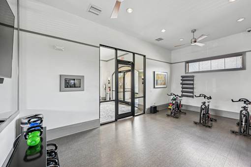 A room with a black stove and a fan on the ceiling.