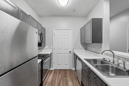 A kitchen with a white door in the middle.