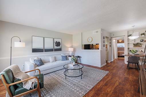 A living room with a white couch, a green chair, and a coffee table.