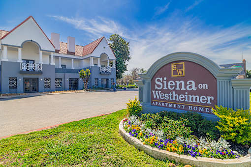 A sign for Siena on Westheimer Apartment Homes is in front of a building.