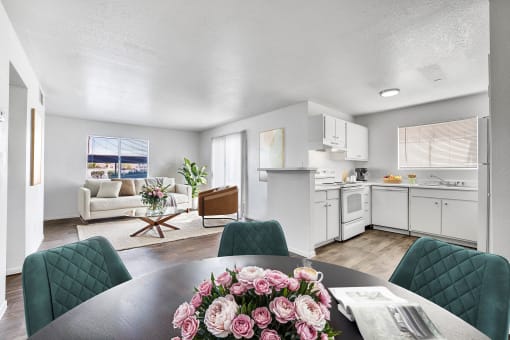 a living room and kitchen with a table with flowers