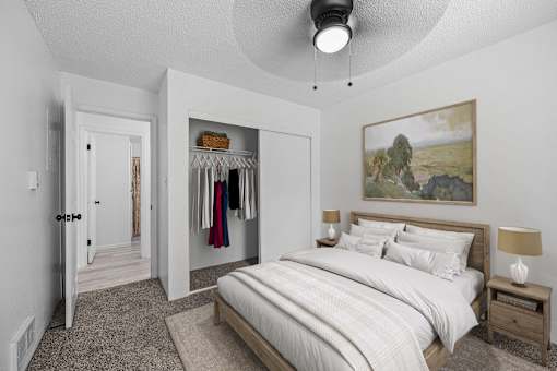 A bedroom with a large bed and a painting on the wall.