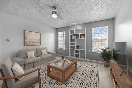 A living room with a grey couch, a wooden coffee table, and a painting on the wall.