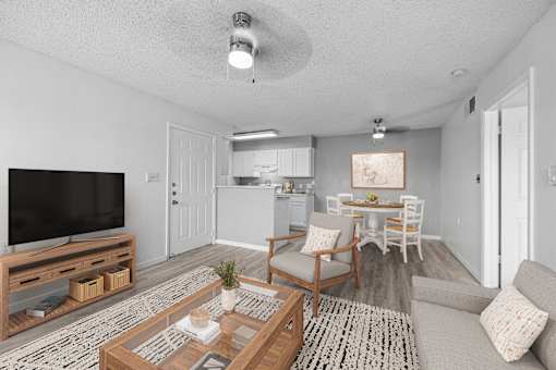 A living room with a television, a couch, and a coffee table.