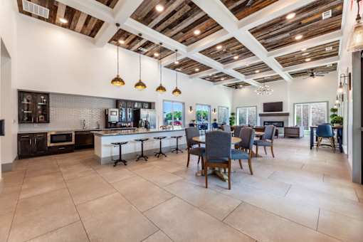 A spacious kitchen and dining area with wooden ceiling beams and tiled flooring.