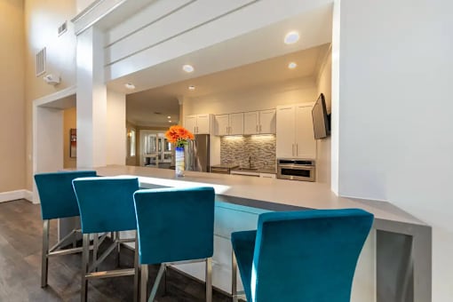 A dining room with a long table and blue chairs.