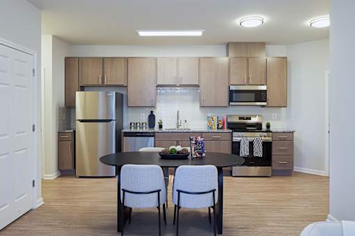 A kitchen with a table and chairs in the middle of the room.