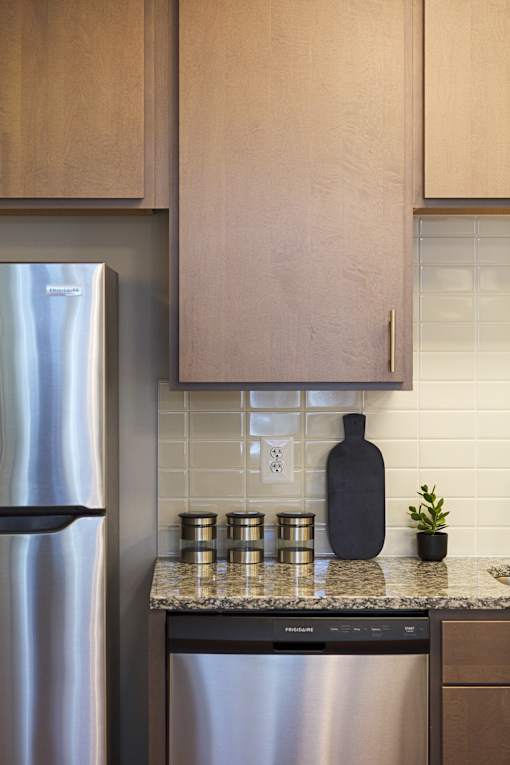 A kitchen with a stainless steel refrigerator and a black pot on the counter.