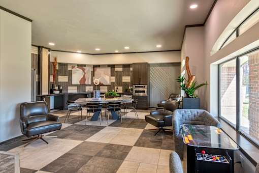 A modern living room with a black leather chair and a grey sofa.
