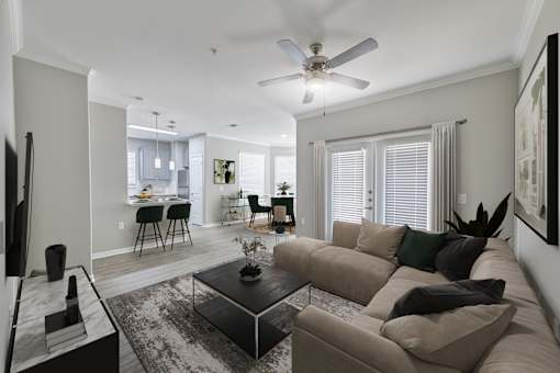 A living room with a couch, a coffee table, and a ceiling fan.