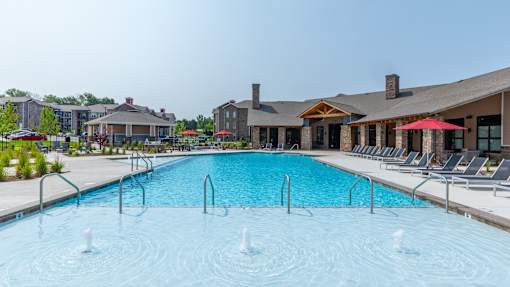 A large swimming pool with a few people in it.