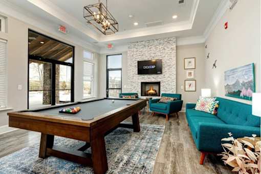 A pool table is in the middle of a room with a blue couch.