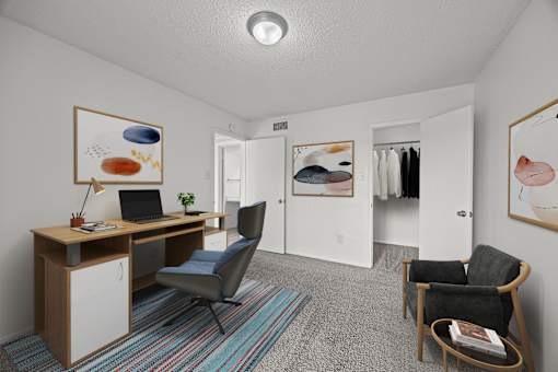 A room with a desk, chair, and artwork on the wall.