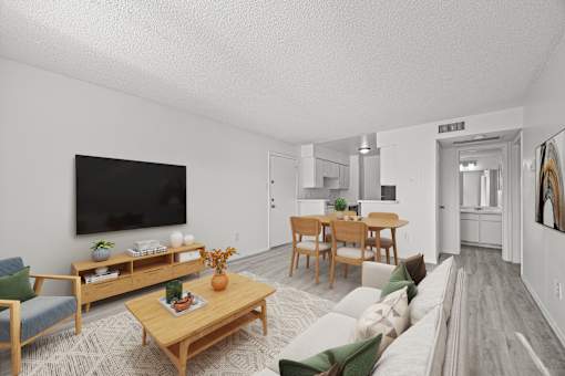 A living room with a couch, chairs, a coffee table, and a television.