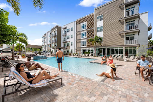People are relaxing by the pool at a resort.