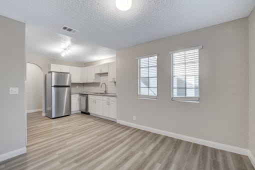 a kitchen with white cabinets and a stainless steel refrigerator