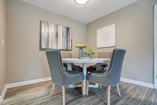 A dining room with a table and chairs.