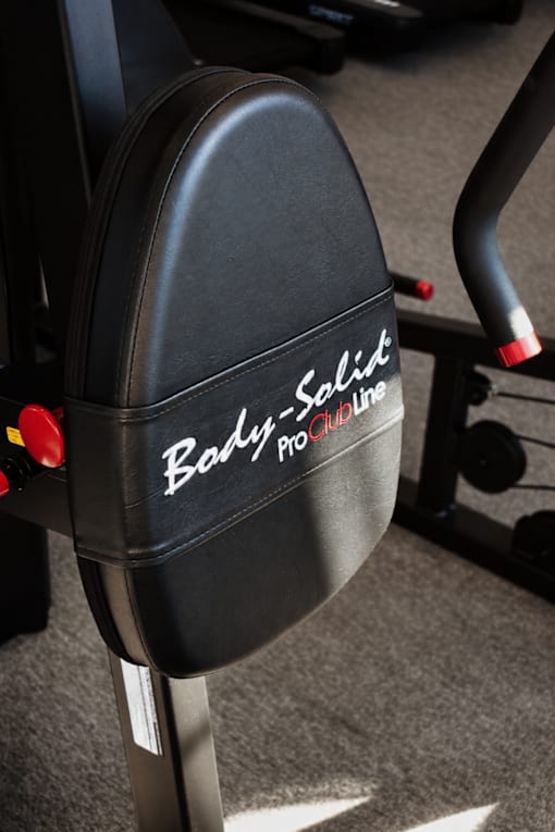 A close up of a black gym chair with the words