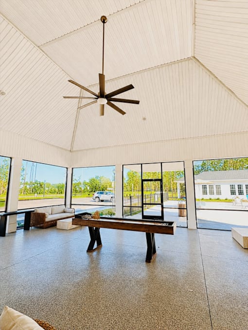 A room with a bench and a ceiling fan.