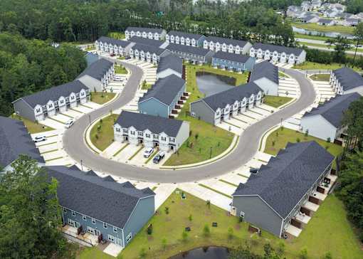 A bird's eye view of a housing complex with a curved road.