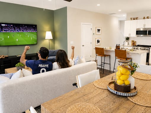 A man and woman are watching a soccer game on television.