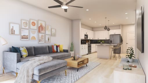 a living room with a grey couch and a coffee table in front of a kitchen with a