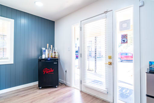 a bar in the corner of a room with blue walls and a glass door