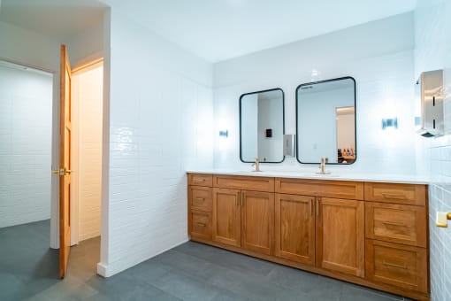 a bathroom with two mirrors and a wooden vanity