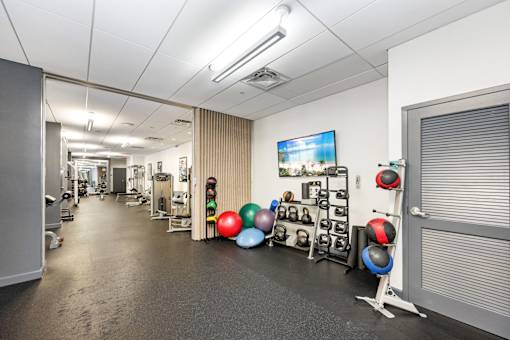 A gym with a variety of equipment including kettlebells.