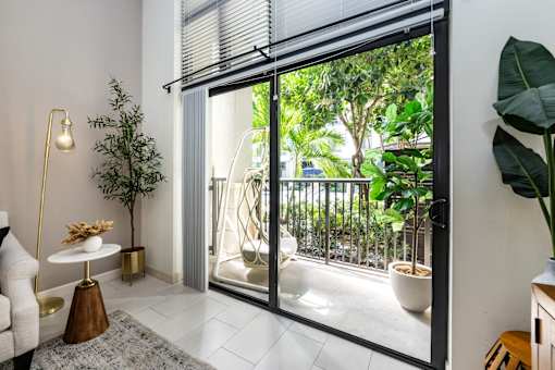 A living room with a sliding glass door leading to a balcony.