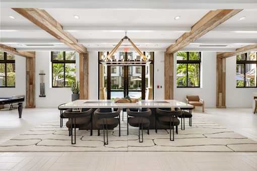 A modern dining room with a glass table and chairs.