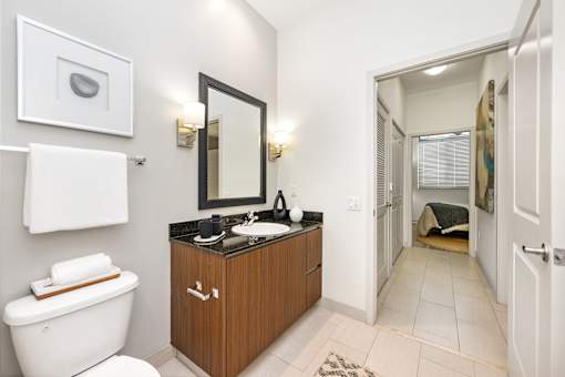 A bathroom with a white toilet, a sink, and a mirror.