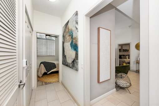 A room with a chair and a painting on the wall.