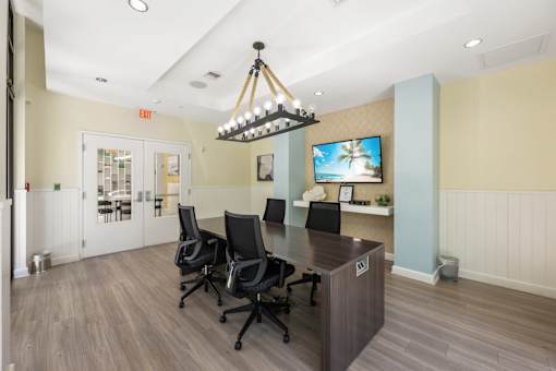A conference room with a long table and chairs.