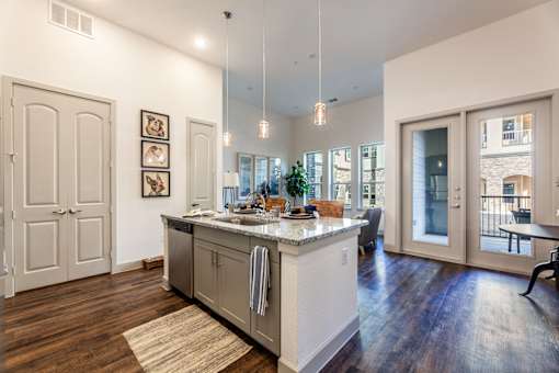 A kitchen with a marble countertop and a view of the city.